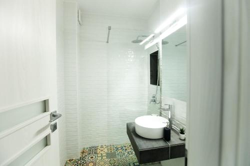 uma casa de banho branca com um lavatório e um espelho em Premium Apartment Sinaia em Sinaia