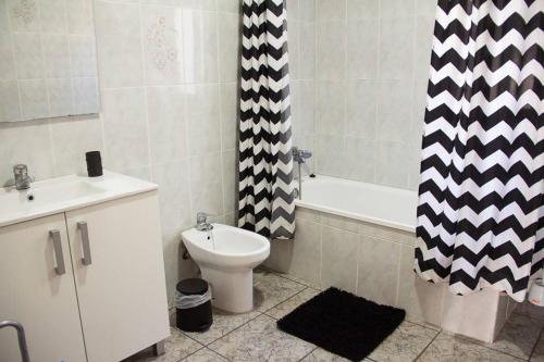 a bathroom with a toilet and a shower curtain at APARTAMENTO LOS NARCISOS in Chulilla