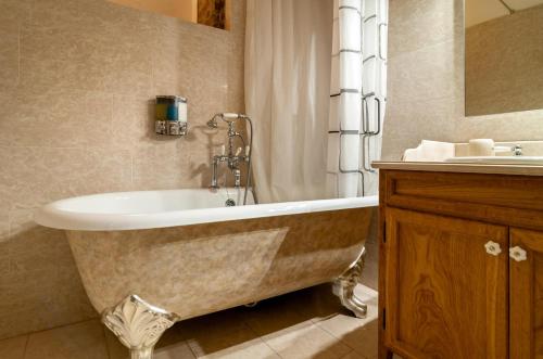 a bathroom with a bath tub and a sink at Castello di Montonate in Mornago