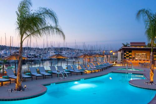 ein Pool mit Stühlen und ein Yachthafen in der Nacht in der Unterkunft Kona Kai Resort & Spa, a Noble House Resort in San Diego