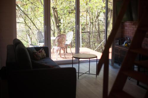 a living room with a couch and a table on a porch at Lawendowo- sauna, basen, domki w ogrodzie i apartamenty w kamienicy in Sandomierz