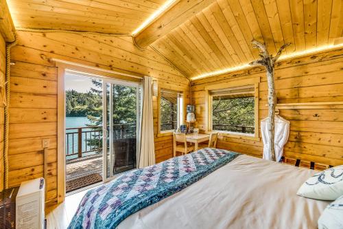 a bedroom with a bed and a window in a log cabin at Stillpoint Lodge - All-Inclusive in Halibut Cove
