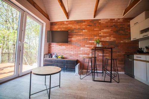 a kitchen with a brick wall and a table and stools at Lawendowo- sauna, basen, domki w ogrodzie i apartamenty w kamienicy in Sandomierz