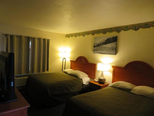 a hotel room with two beds and a flat screen tv at Carquinez Inn in Vallejo