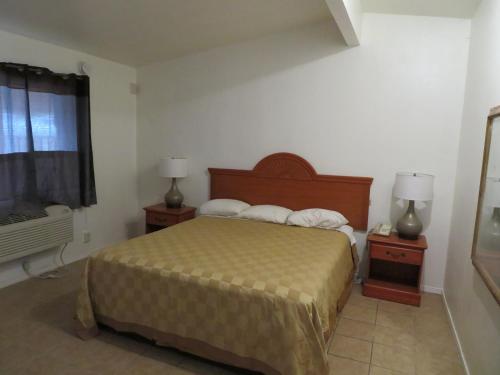 a bedroom with a bed and two night stands with lamps at Carquinez Inn in Vallejo