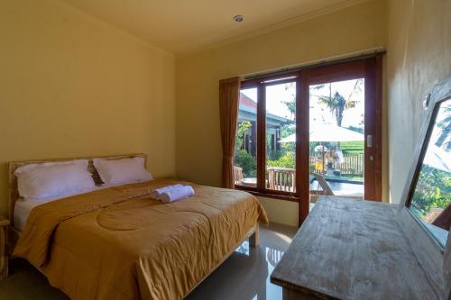 une chambre avec un lit et une grande fenêtre dans l'établissement Dicky Guest House 2 Batu Bolong, à Canggu
