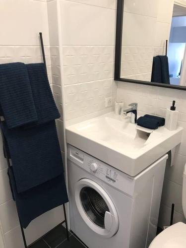 une salle de bain avec une machine à laver et un lavabo dans l'établissement STUDIO CONTEMPORAIN CANNES, à Cannes