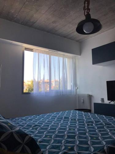 une chambre avec un lit et une grande fenêtre dans l'établissement STUDIO CONTEMPORAIN CANNES, à Cannes