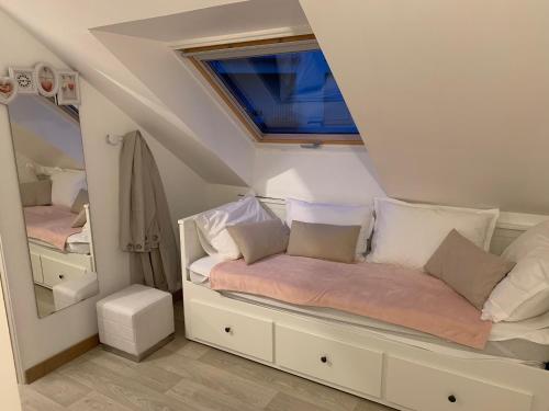 Cette petite chambre dispose d'un lit et d'une fenêtre. dans l'établissement UN BALCON SUR LA MER, ACCES DIRECT A LA PLAGE, à Granville