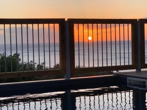 a view of the ocean from a balcony at sunset at Les Cabanes Perchées in Bouillante