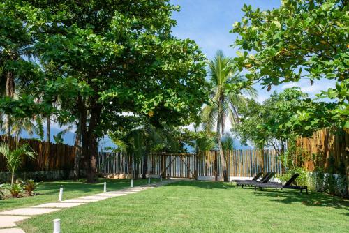 a yard with benches and a fence and trees at Vistabela Resort & Spa in São Sebastião