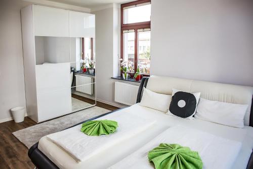a bedroom with a white bed with green pillows at DD Apartments in Dresden
