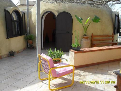 een patio met een stoel en een bank voor een gebouw bij Bungalow a Triscina di Selinunte in Triscina