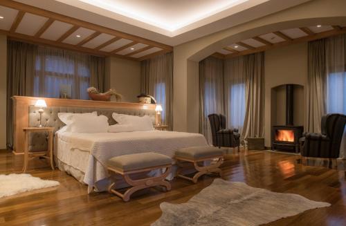 a bedroom with a large bed and a fireplace at Villa Beluno Hotel & Spa in San Carlos de Bariloche
