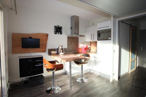 - une cuisine avec une table et des tabourets dans une pièce dans l'établissement Studio Ttikia, à Cambo-les-Bains