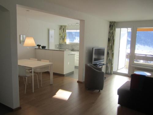 a living room with a kitchen and a table with a dining room at Apartment Alpenblick Superior in Davos