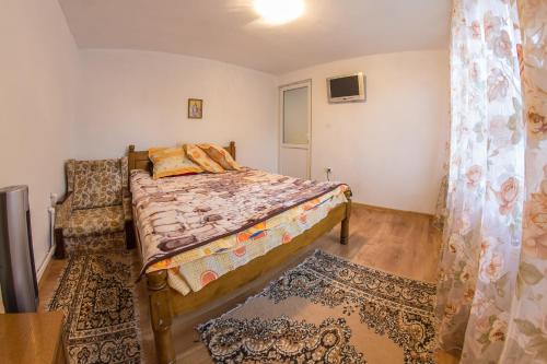 a bedroom with a bed and a chair at Casa de vacanta Jeny in Novaci-Străini