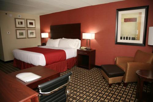 a hotel room with a bed and a desk and chair at Holiday Inn New London by IHG in New London