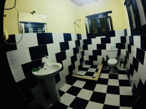 a bathroom with a black and white checkered floor at villa tunis village in ‘Izbat an Nāmūs