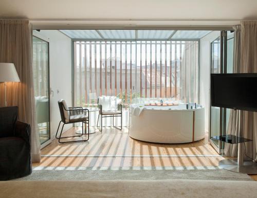 a living room with a tub and a table with chairs at Inspira Liberdade Boutique Hotel in Lisbon