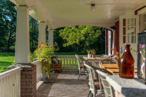 a porch with chairs and tables on a house at Pensionat Haga Öland in Löttorp