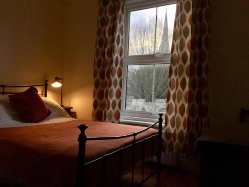 a bedroom with a bed and a window at Cathedral View in Salisbury