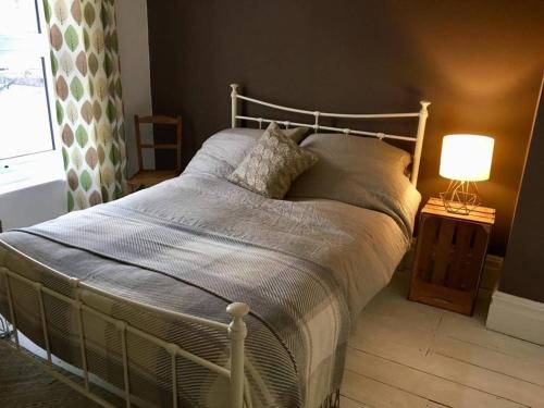 a bed in a bedroom with a lamp on a table at Cathedral View in Salisbury