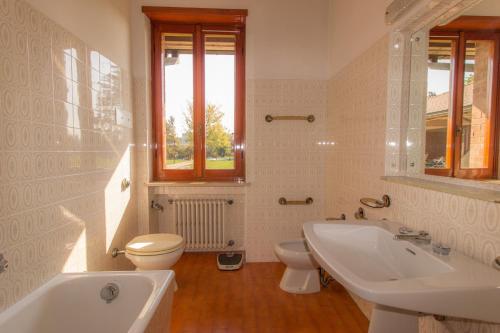 Baño blanco con lavabo y aseo en Agriturismo i Quercioli, en Parma