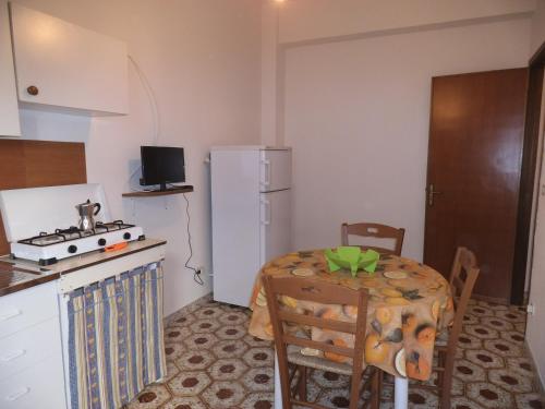 una piccola cucina con tavolo e frigorifero bianco di Le spezie 2PD a Castellammare del Golfo