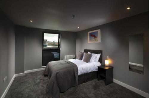 um quarto com uma cama grande e uma janela em Luxury Apartments Newcastle em Newcastle upon Tyne