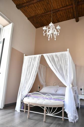 a bedroom with a canopy bed with a chandelier at B&B A due passi in Caserta
