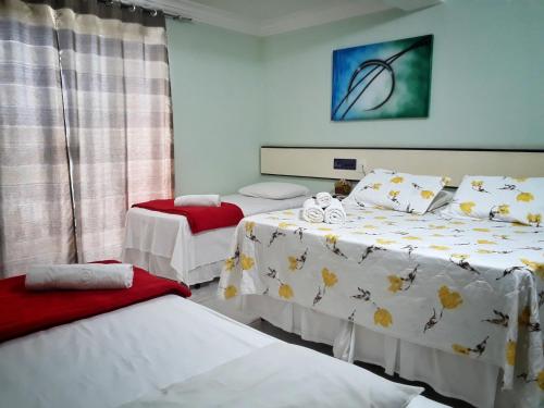 a room with two beds and a window at 5C Hotel in Santo Antônio de Jesus