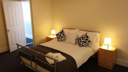 een slaapkamer met een bed met kussens en 2 lampen bij South Shield's Hidden Gem Amethyst 3 Bedroom House Sleeps 6 Guests in South Shields