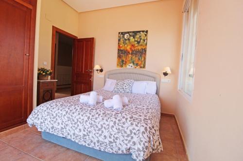 a bedroom with a bed with two towels on it at Villa Babilonia in Guardamar del Segura