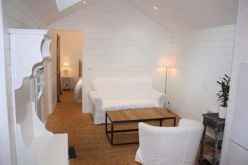 un salon avec un canapé blanc et une table dans l'établissement Maison Kador, à Crozon