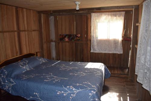 - une chambre avec un lit bleu et une fenêtre dans l'établissement Casa Hospedaje Tingomaria, à Tingo María