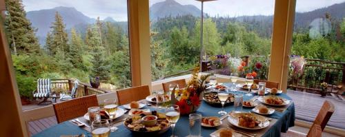 a table with plates of food on top of a balcony at Stillpoint Lodge - All-Inclusive in Halibut Cove