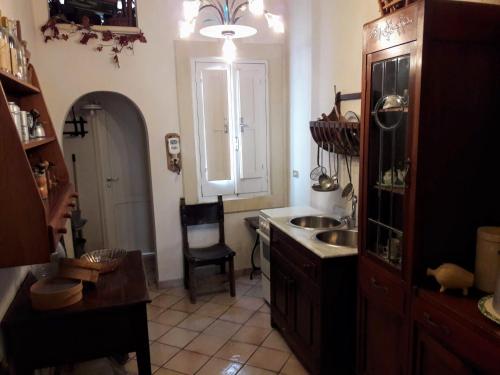 una cucina con lavandino, tavolo e sedia di Casa a Corte - Il Tramontana a Melendugno