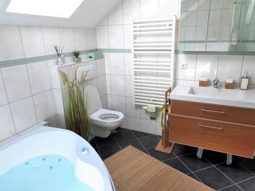 ein Badezimmer mit einer Badewanne, einem WC und einem Waschbecken in der Unterkunft FeWo Atterseeperle - 80m2 mit See- und Gebirgsblick in Steinbach am Attersee