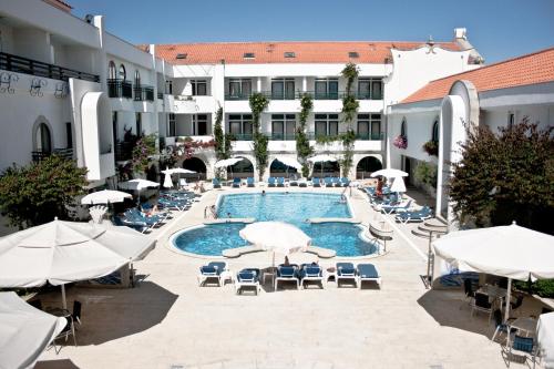 uma piscina com cadeiras e guarda-sóis ao lado de um edifício em Hotel Suave Mar em Esposende