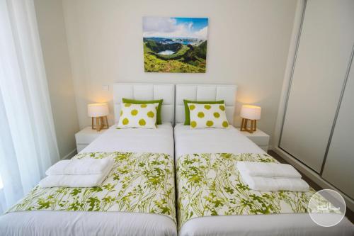 a bedroom with a white bed with yellow and green pillows at Moderne Villa in Salir do Porto - Villa nas dunas in Salir do Porto