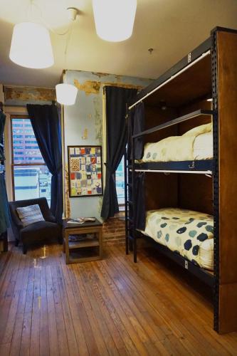 a bedroom with two bunk beds and a chair at Hostel Fish in Denver
