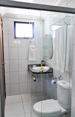 a white bathroom with a toilet and a sink at 5C Hotel in Santo Antônio de Jesus