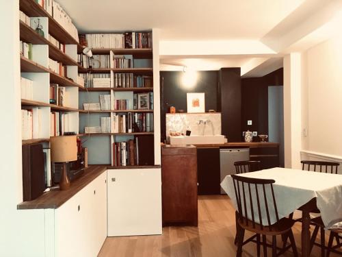 une cuisine et une salle à manger avec une table et une étagère. dans l'établissement Elegant and cosy flat near Montmartre, à Paris