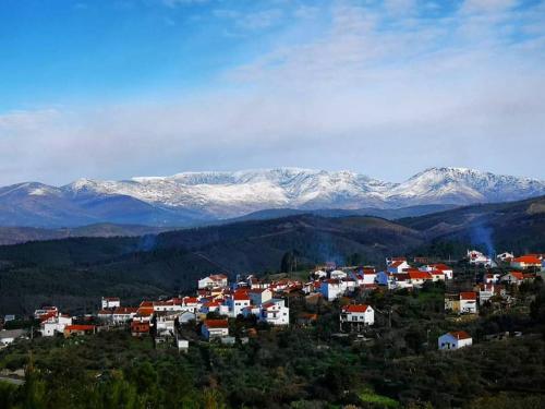 una pequeña ciudad con montañas cubiertas de nieve en el fondo en CASA TITA, en Lavacolhos