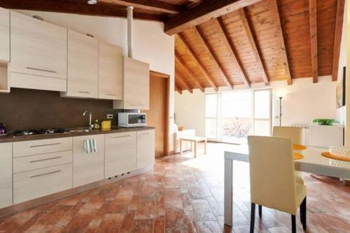 een keuken met witte kasten en een tafel met stoelen bij New Attic Lake View 5 in Varenna