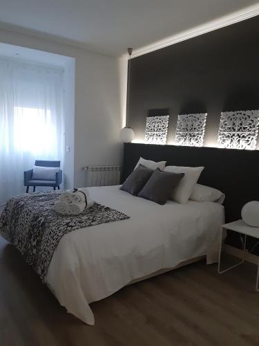 a bedroom with a large white bed and a window at La parada de Conde Aranda in Zaragoza
