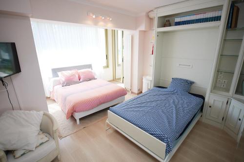 a small bedroom with a bed and a tv at Appartement Luxueux 150m2 - Cannes in Cannes