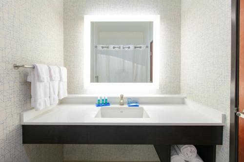 y baño con lavabo blanco y espejo. en Holiday Inn Express Hotel & Suites Seaside Convention Center, an IHG Hotel, en Seaside