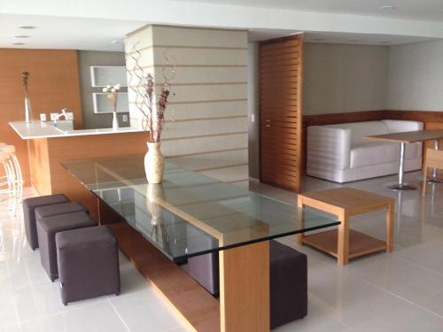 a dining room with a glass table and chairs at Vista Espetacular Porto Real suítes in Mangaratiba